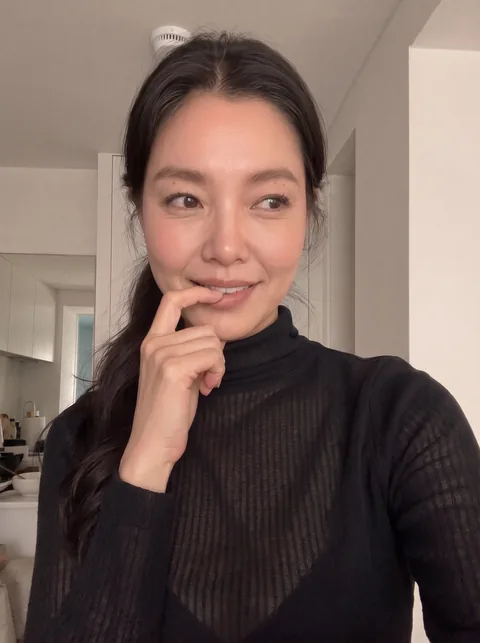 Nina in a black turtleneck with her hair tied back