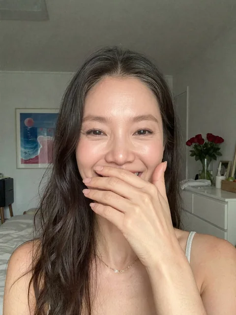 Nina laughing with her hand over her mouth